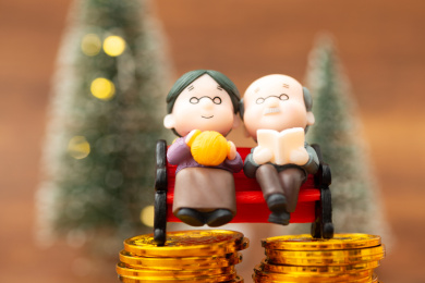 在桌子上的老年人与金币，养老概念