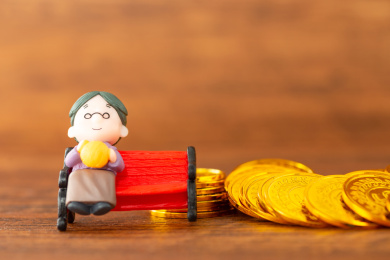 在桌子上的老年人与金币，养老概念