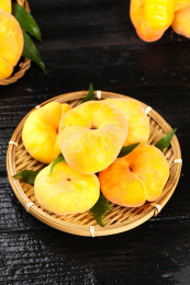 黑底上放着一盘黄肉蟠桃