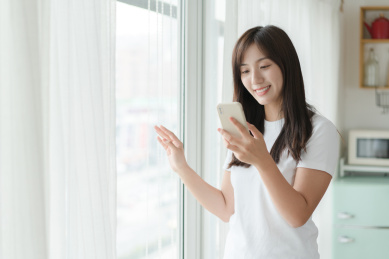 女人在窗边使用手机视频通话