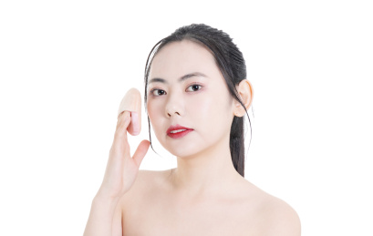 使用粉饼化妆的美容女性肖像