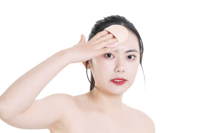 使用粉饼化妆的美容女性肖像