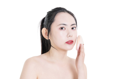 使用粉饼化妆的美容女性肖像