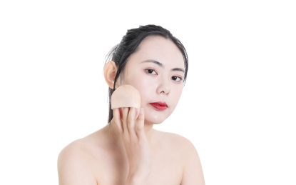 使用粉饼化妆的美容女性肖像