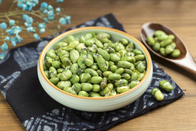 一盘干炒青豆爆青豆摆放在木桌面上特写