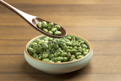 一盘干炒青豆爆青豆摆放在木桌面上特写