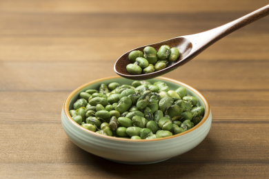 一盘干炒青豆爆青豆摆放在木桌面上特写