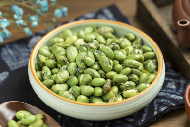 一盘干炒青豆爆青豆摆放在木桌面上特写