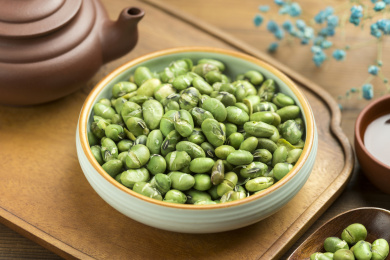 一盘干炒青豆爆青豆摆放在木桌面上特写