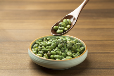 一盘干炒青豆爆青豆摆放在木桌面上特写