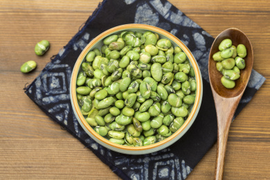 一盘干炒青豆爆青豆摆放在木桌面上特写