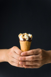 手持一个香草巧克力甜筒冰淇淋