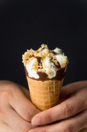 手持一个香草巧克力甜筒冰淇淋