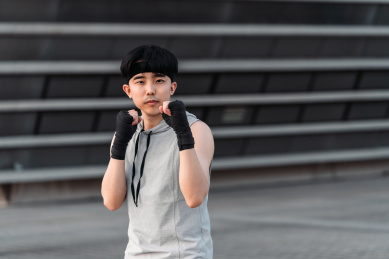 亚洲运动男生在户外练习拳击防御式