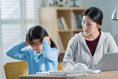 年轻妈妈和做作业的女儿生气