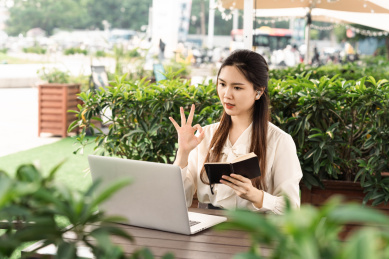 亚洲商务女士一边看电脑一边做笔记