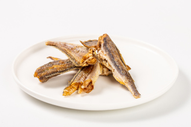 白色背景上满满一碗即食小吃小鱼干