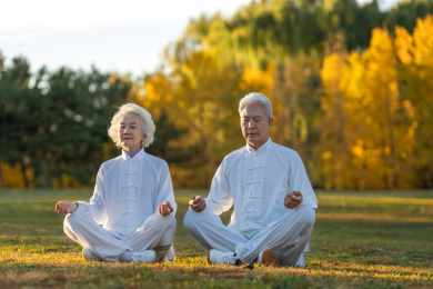 坐在草地上打坐的老年夫妇