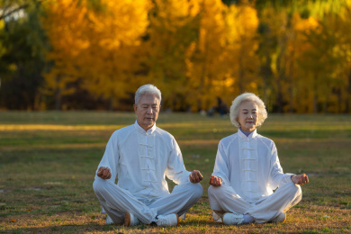 坐在草地上打坐的老年夫妇
