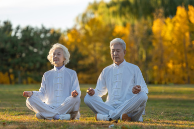 坐在草地上打坐的老年夫妇