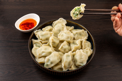 黑色木纹桌面上的鲅鱼馅饺子