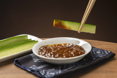 夏季凉菜黄瓜蘸黄豆酱特写木桌面背景