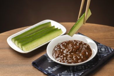 夏季凉菜黄瓜蘸黄豆酱特写木桌面背景