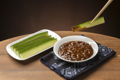 夏季凉菜黄瓜蘸黄豆酱特写木桌面背景