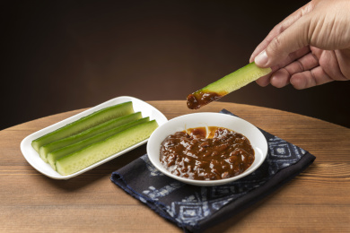 夏季凉菜黄瓜蘸黄豆酱特写木桌面背景