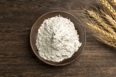 一盘面粉与麦穗摆放在木桌面上特写深色调