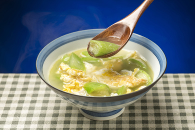 一碗丝瓜鸡蛋汤摆放在桌面上特写