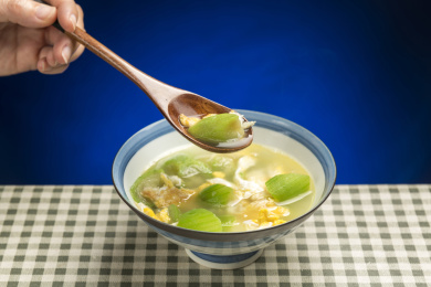 一碗丝瓜鸡蛋汤摆放在桌面上特写