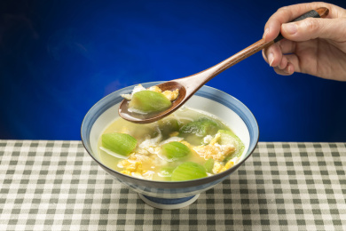 一碗丝瓜鸡蛋汤摆放在桌面上特写