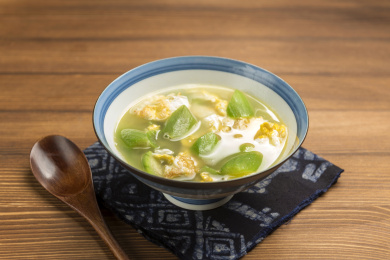 一碗丝瓜鸡蛋汤摆放在桌面上特写