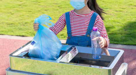 公园里一名中国小女孩在扔垃圾