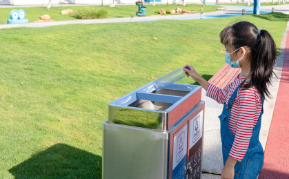 公园里一名中国小女孩在扔垃圾