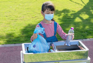 公园里一名中国小女孩在扔垃圾