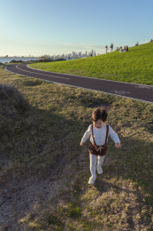 黄昏时城市海滩上奔跑小男孩