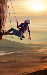 青年女人在悬崖峭壁上攀岩