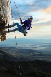 青年女人在悬崖峭壁上攀岩