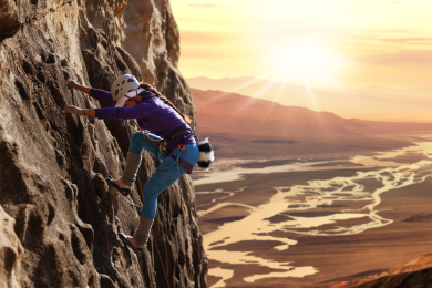 青年女人在悬崖峭壁上攀岩