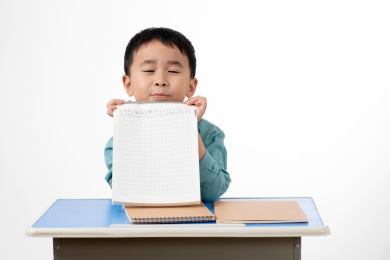 男孩在白色背景下拿着作业本