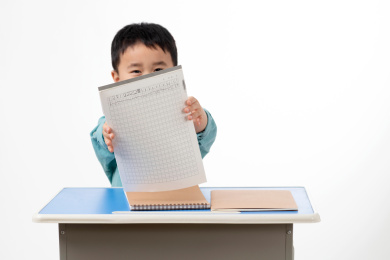 男孩在白色背景下拿着作业本