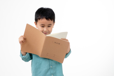 男孩在白色背景下拿着作业本
