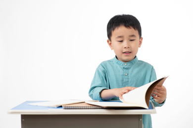 男孩在白色背景下拿着作业本