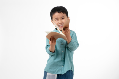 男孩在白色背景下拿着作业本