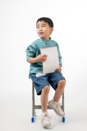 男孩在白色背景下拿着作业本