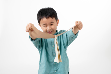 男孩在白色背景下拿着作业本