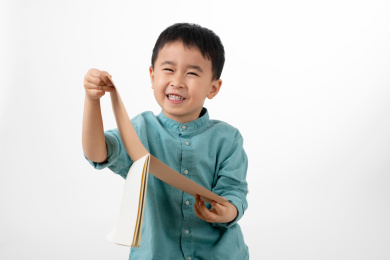 男孩在白色背景下拿着作业本