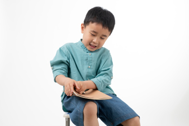 男孩在白色背景下拿着作业本